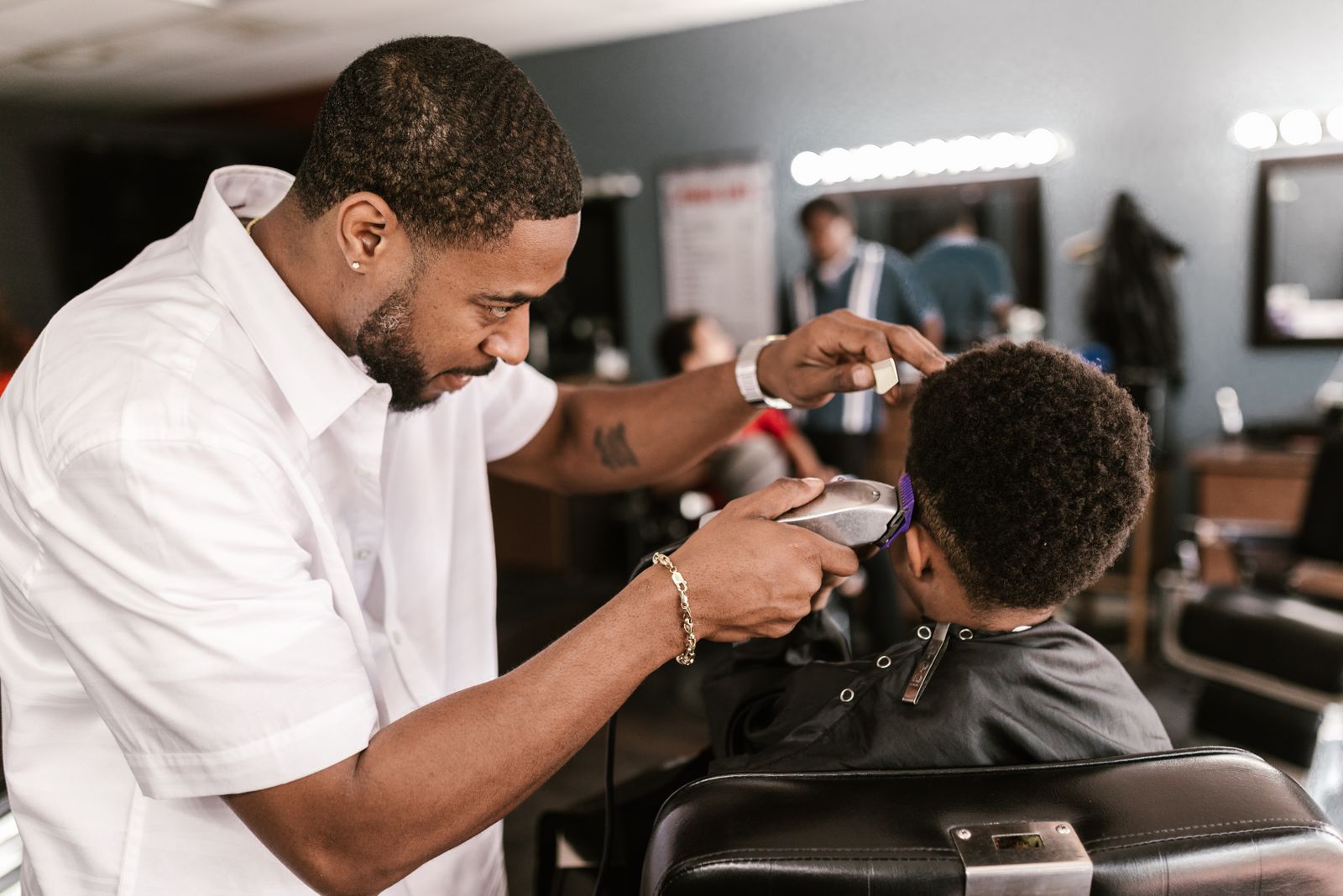 Barber shaving a young boy's hair